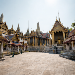 Location Prompt: Grand ancient Thai palace courtyard exterior, bright daytime. Magnificent traditional Thai architecture